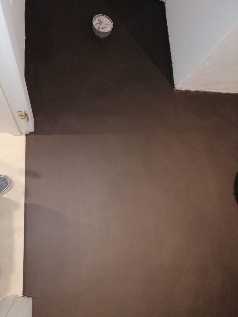 Finished dark seamless microcement bathroom floor with no grout lines