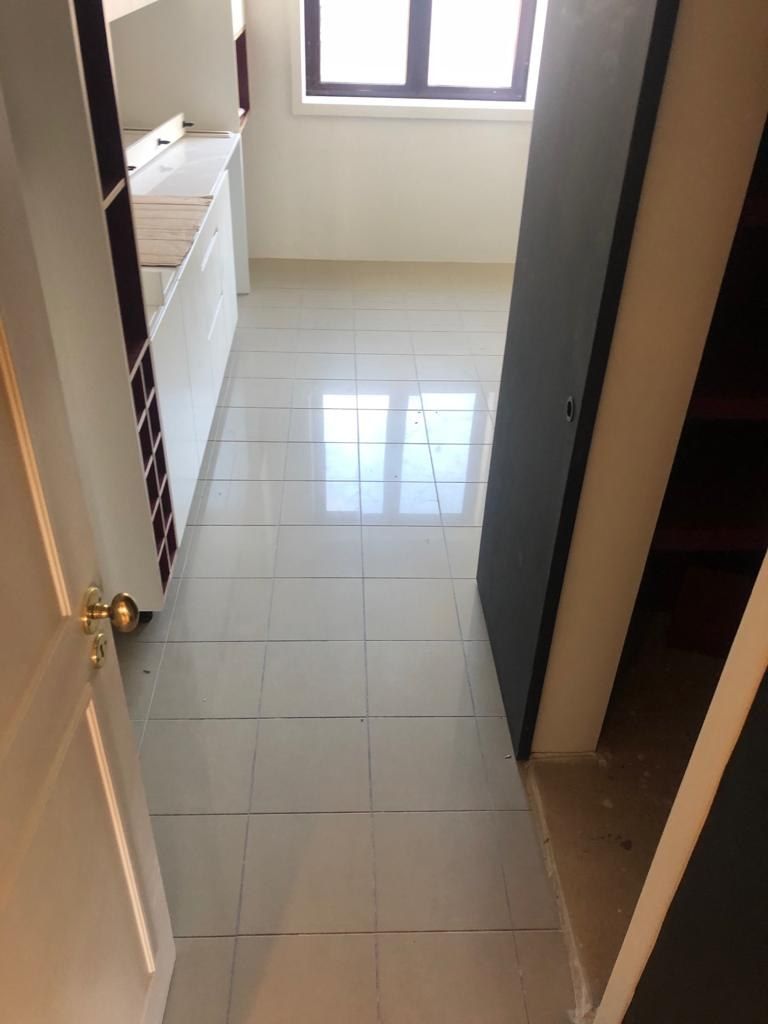 Glazed floor tiles in a hallway before microcement was applied